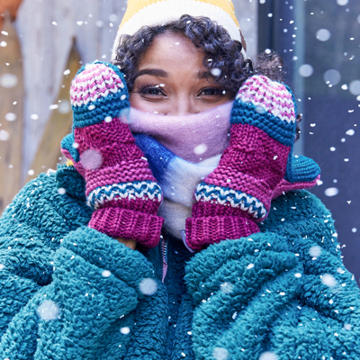 Women in snow wearing mittens and scarf