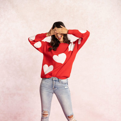 Woman wearing red sweatshirt with white hearts