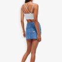 Blue Medium Distressed Denim Mini Skirt With Front Button Detail, Pockets, Raw Hem, And Faded Wash