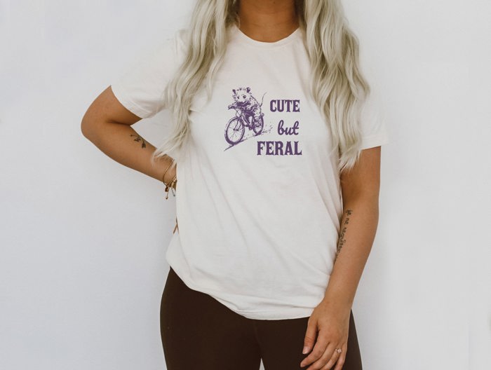 Cute But Feral Little Possum on A Bike Funny Cute Sarcastic Shirts Vintage Animal Sayings Soft Cozy Longer Length Unisex Graphic Tee T-shirt