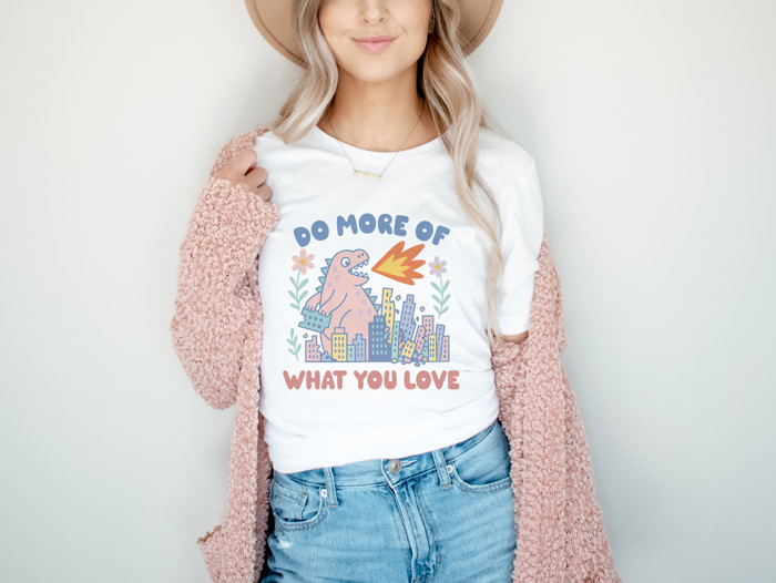 DO MORE OF WHAT YOU LOVE | Unleash the Joy: A Dinosaur's Delight Soft Cozy Longer Length Unisex Graphic Tee T-shirt