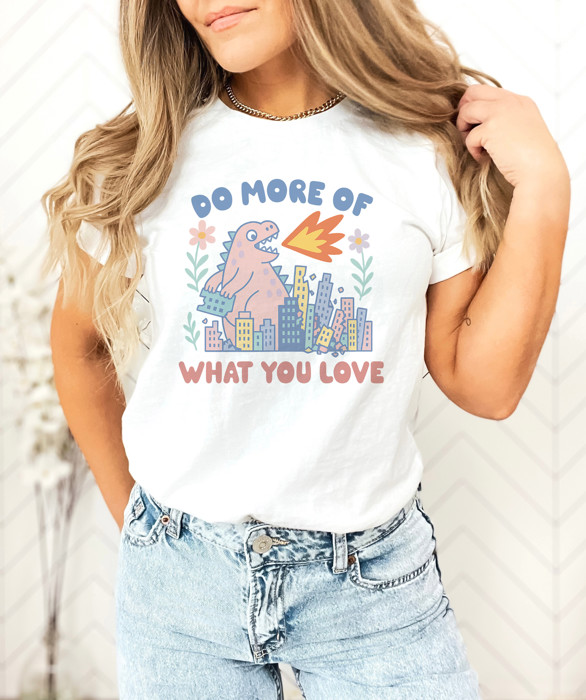 DO MORE OF WHAT YOU LOVE | Unleash the Joy: A Dinosaur's Delight Soft Cozy Longer Length Unisex Graphic Tee T-shirt