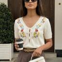 Medium Embroidered Knit Top with Floral Detailing Tie Front V Neckline Soft Lightweight Feel Short Sleeves and Feminine Relaxed Silhouette Perfect for Casual Outings Brunch and Effortless Everyday Style